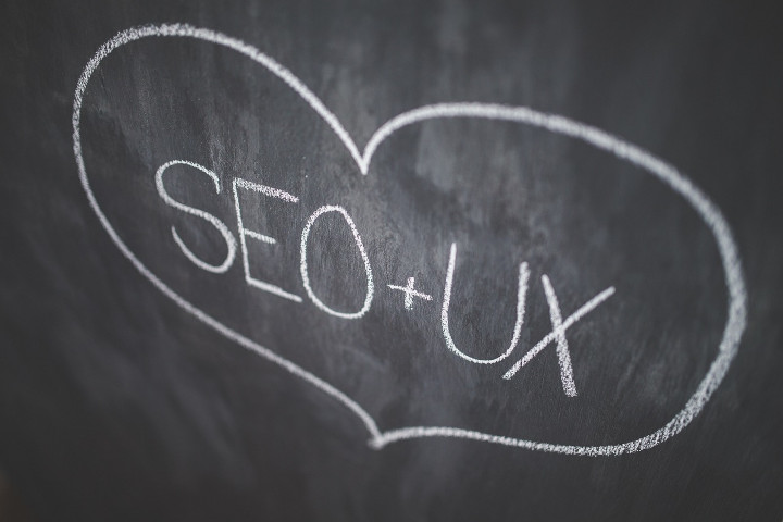Ein Herz mit weißer Kreide, in dem SEO ein Plus-Zeichen und UX steht